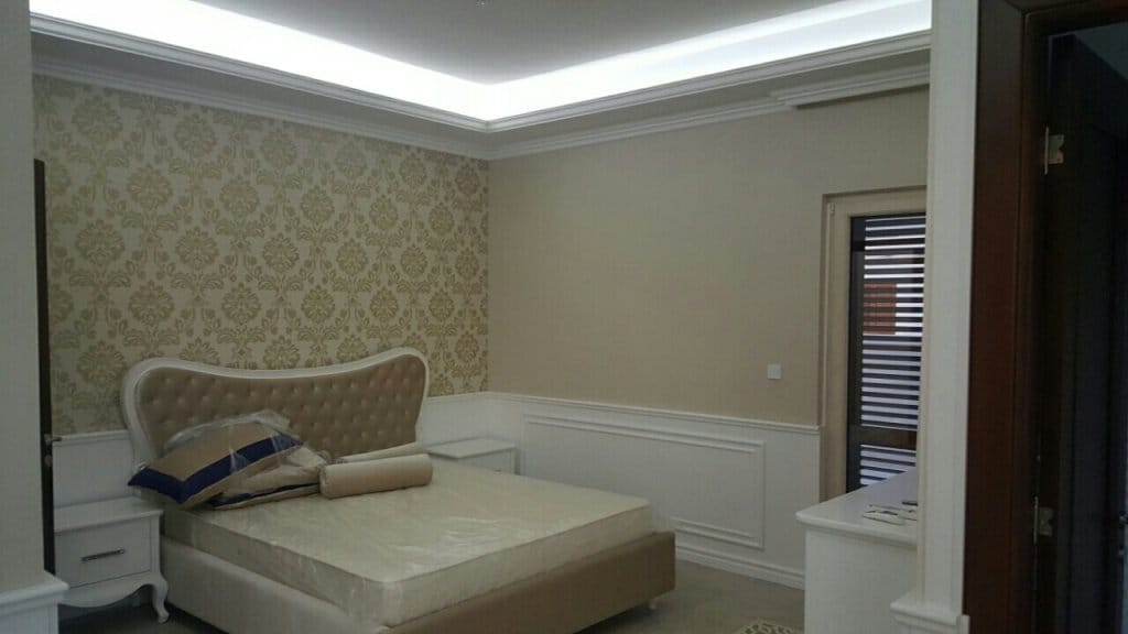 Classic-style bedroom in a villa in Reževići, Montenegro: double bed, patterned wallpaper, and hidden lighting.