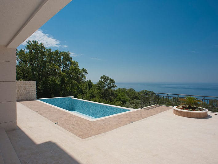 Terrace with a pool and panoramic sea view at a villa in Reževići, Montenegro: modern finishes and landscaping.