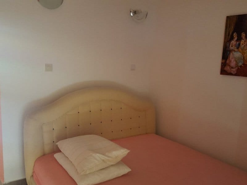 Cozy bedroom with a double bed in a house for sale, Krumovica, Montenegro: bright interior and wall decor.