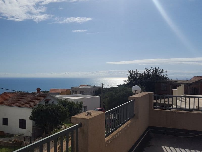 Panoramic sea view from the balcony of a house in Krimovica, Montenegro: terrace with railing and coastal scenery.