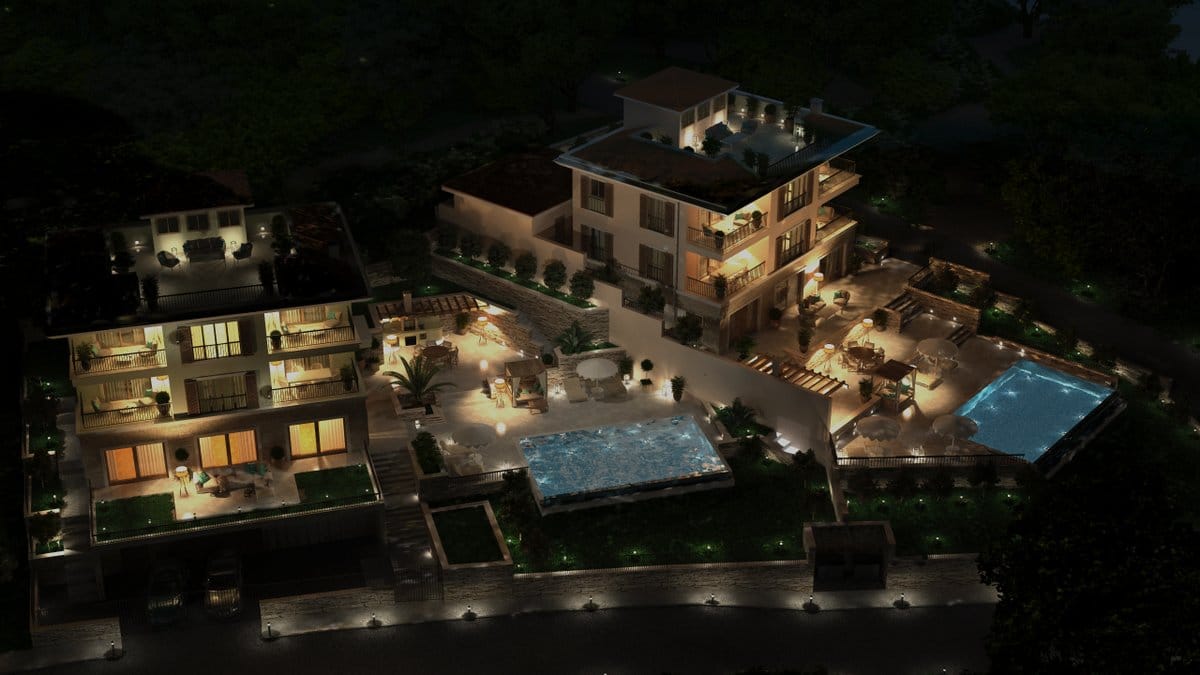 Night villa in Reževići, Montenegro: aerial view of two buildings with pools, terraces, and landscape lighting.
