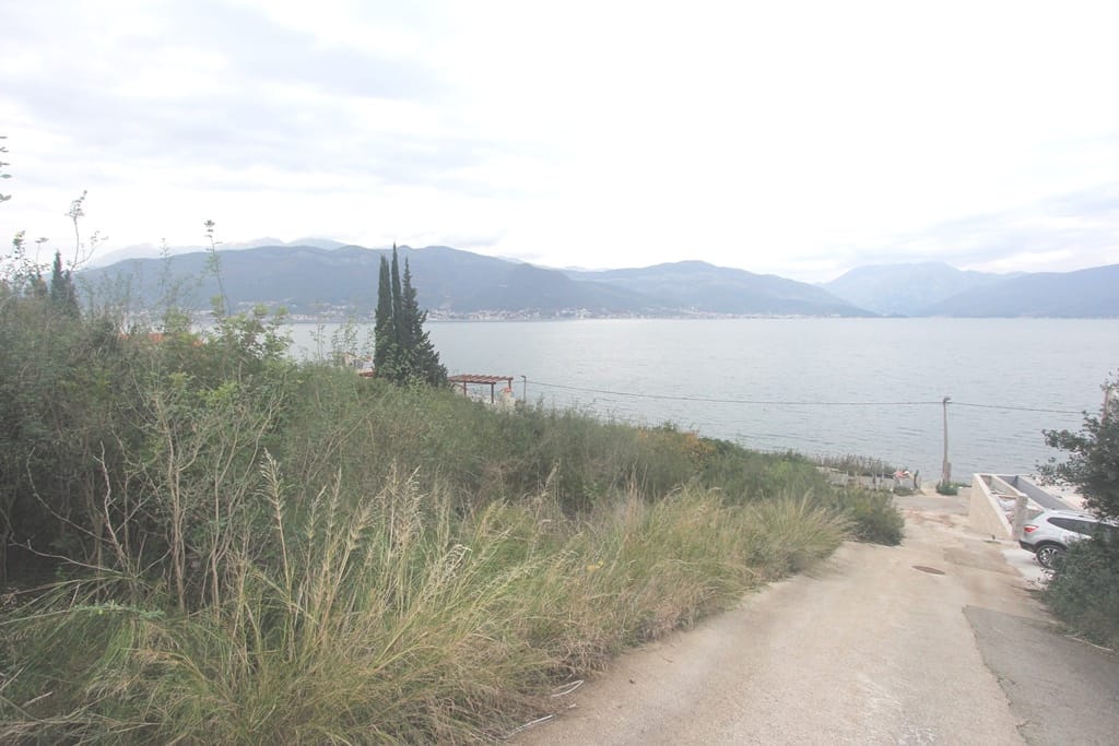 Land plot in Krašići, Montenegro with panoramic sea and mountain views, access road to the property.