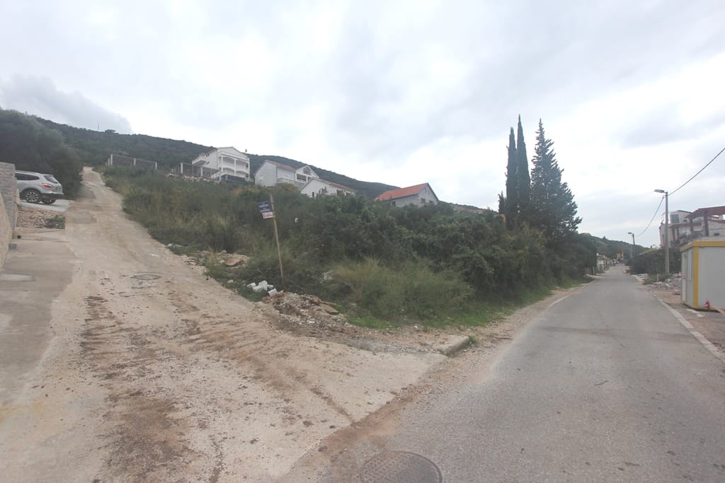 Building plot in Krašići, Montenegro: view of the access road and hilly terrain.