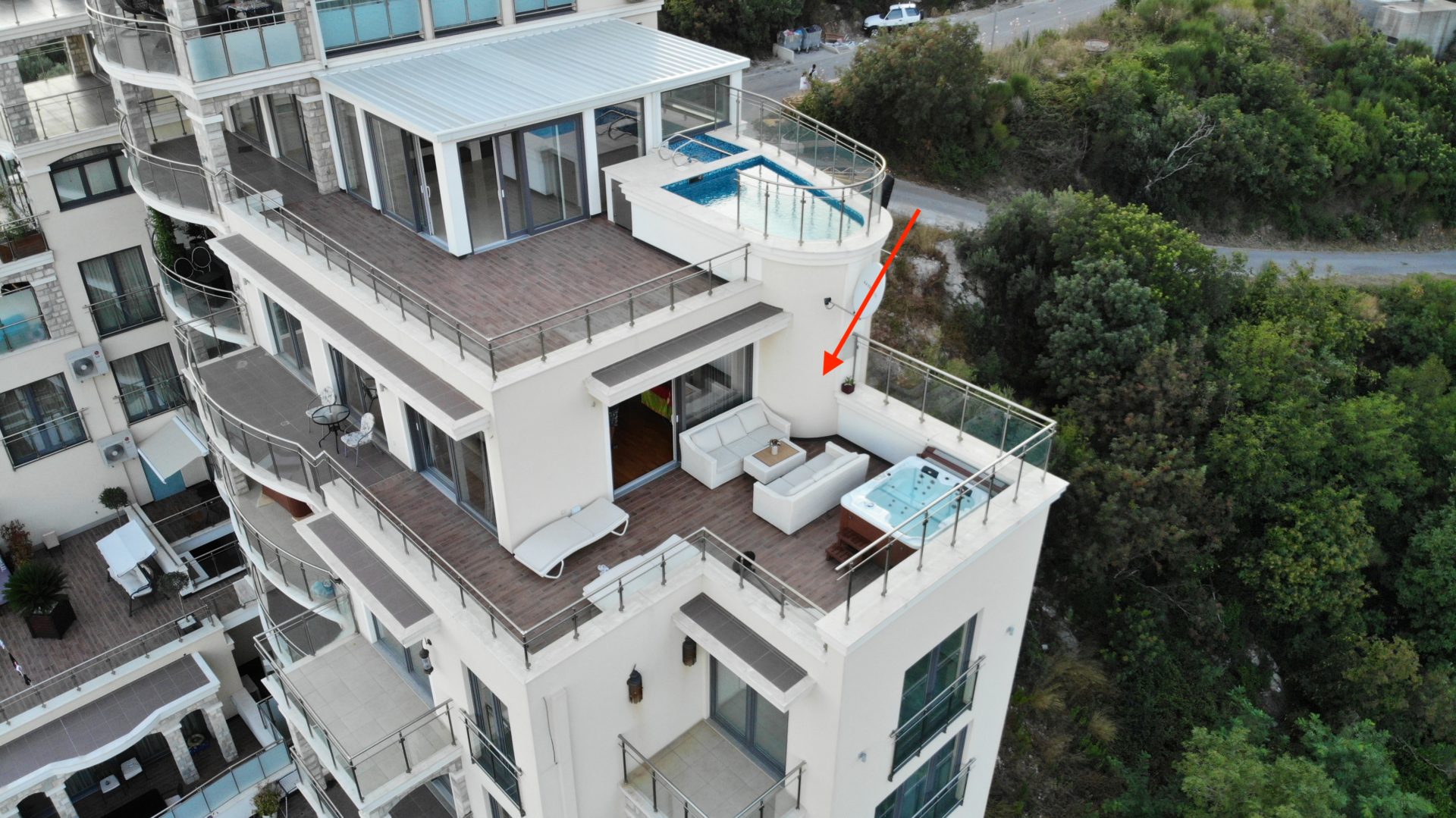 Penthouse in Bečići, Montenegro: terrace with jacuzzi, lounge furniture, and sea view in a luxury residential complex.