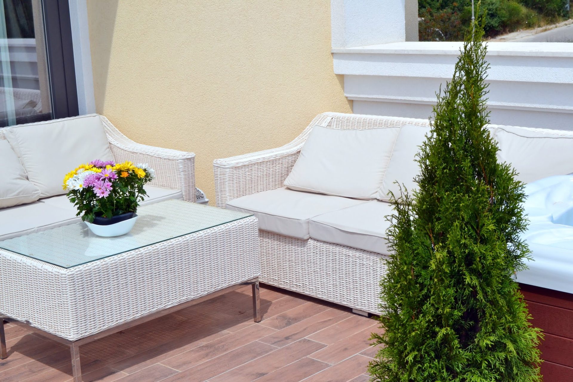 Cozy terrace with wicker furniture and a jacuzzi in an apartment in Bečići, Montenegro: view of the balcony with flowers and decor.