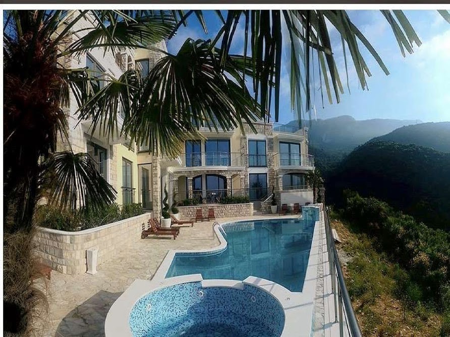 Pool and jacuzzi on the terrace of a luxury villa in Bečići, Montenegro, with panoramic mountain and sea views.