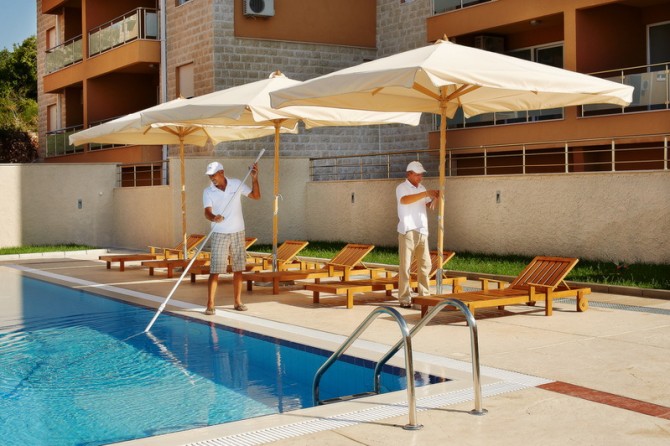 Pool area maintenance in a residential complex in Bečići, Montenegro: sun loungers, umbrellas, and modern landscaping.