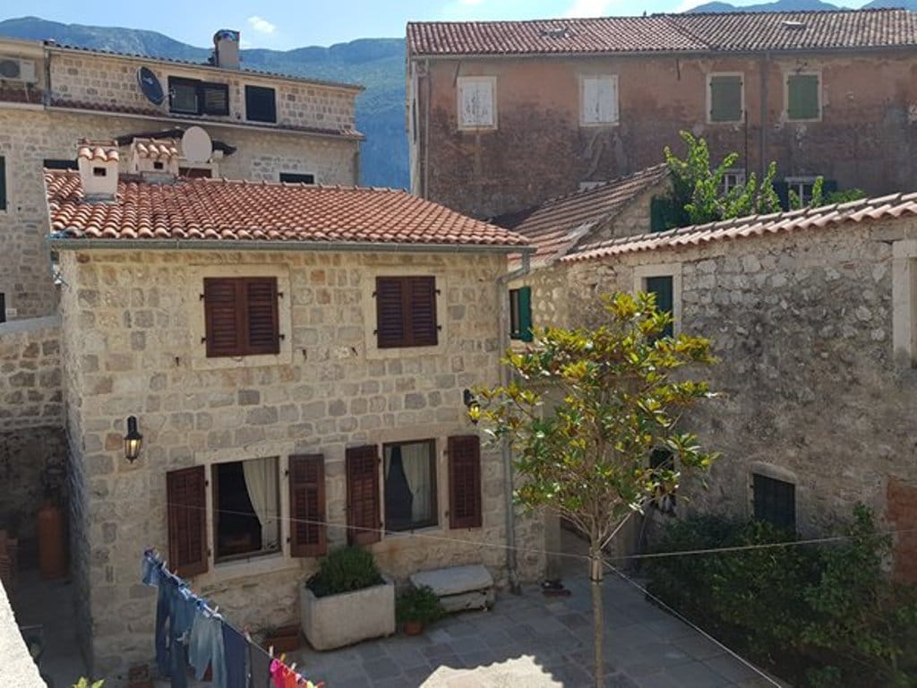 Stone house in Mediterranean style with a tiled roof and a cozy courtyard in Prčanj, Montenegro.