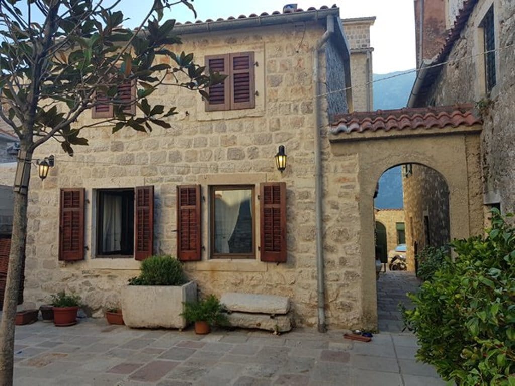 Facade of a stone villa in Mediterranean style with wooden shutters in Prčanj, Montenegro.