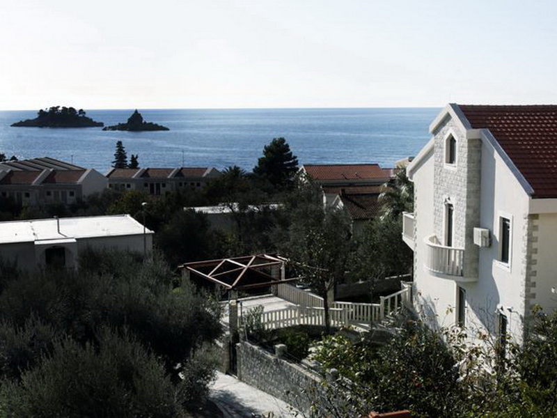 Villa in Petrovac, Montenegro: view of the house with stone cladding, a terrace, and panoramic views of the sea and islands.