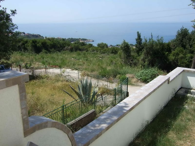 Sea view and green plot from the house terrace in Utjeha, Montenegro: fenced area with agave and panoramic landscape.
