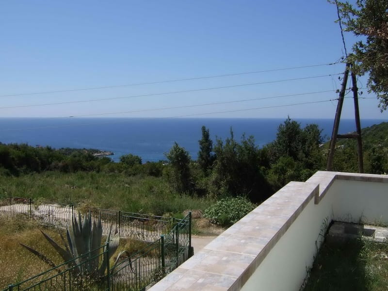 Panoramic sea view from the house terrace in Utjeha, Montenegro: green plot, fence, and seascape.