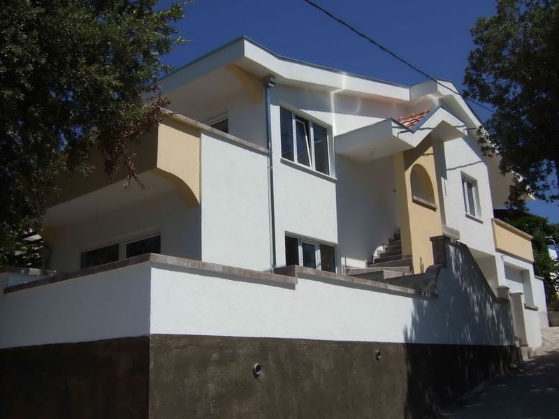 Two-story house with a white facade and terrace in Uteha, Montenegro: modern architecture and exterior finish of the building.