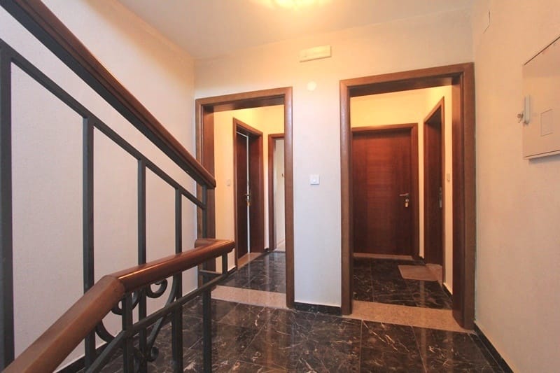 Hallway with staircase and marble floor in a house for sale, Krimovica, Montenegro: view of the interior doors.