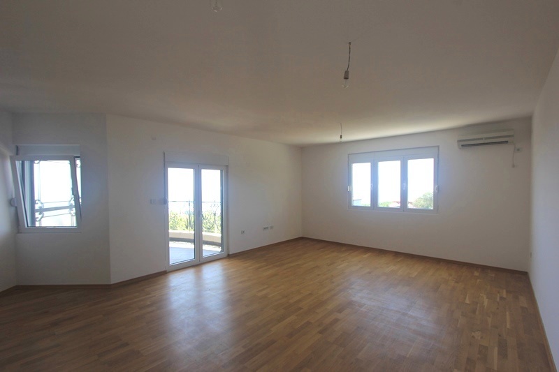 Spacious living room with parquet flooring and access to the terrace in a house, Krymovitsa, Montenegro. Bright room with air conditioning.