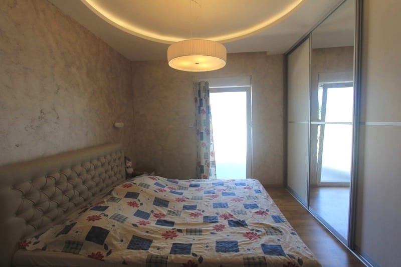 Bedroom in a house in Krimovica, Montenegro: a double bed with a soft headboard, a mirrored sliding wardrobe, and access to the terrace.