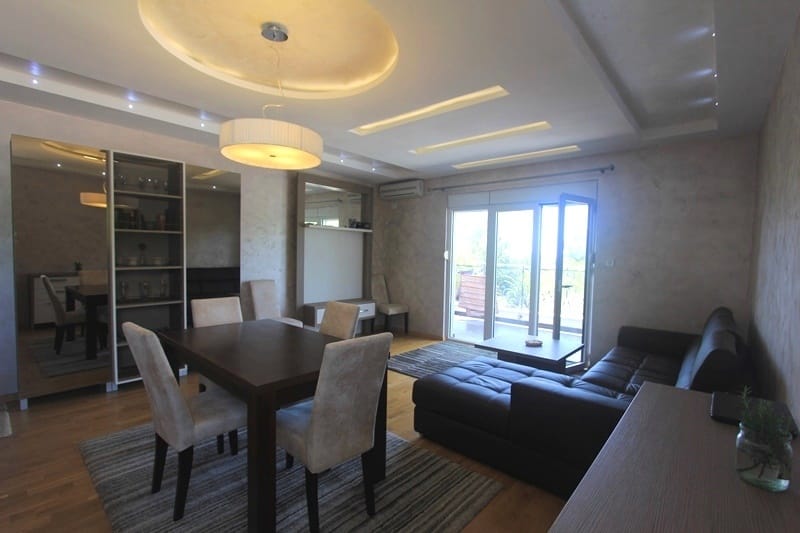 Living room with dining area and access to the terrace in a house, Krimovica, Montenegro: modern interior, leather sofa.