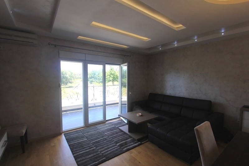 Living room in a house in Krimovica, Montenegro: black leather sofa, designer ceiling with lighting, and access to the terrace.