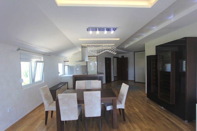 Modern living room with dining area in a house, Krimovica, Montenegro: stylish furniture, parquet flooring, and designer lighting.
