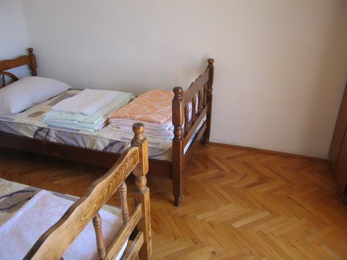 Bedroom with two wooden beds and parquet flooring in a house for sale in Bečići, Montenegro