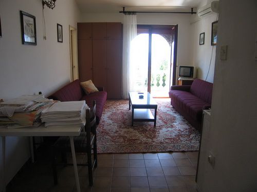 Living room in a house in Bečići, Montenegro: two sofas, a coffee table, a rug, and access to a balcony with a view.