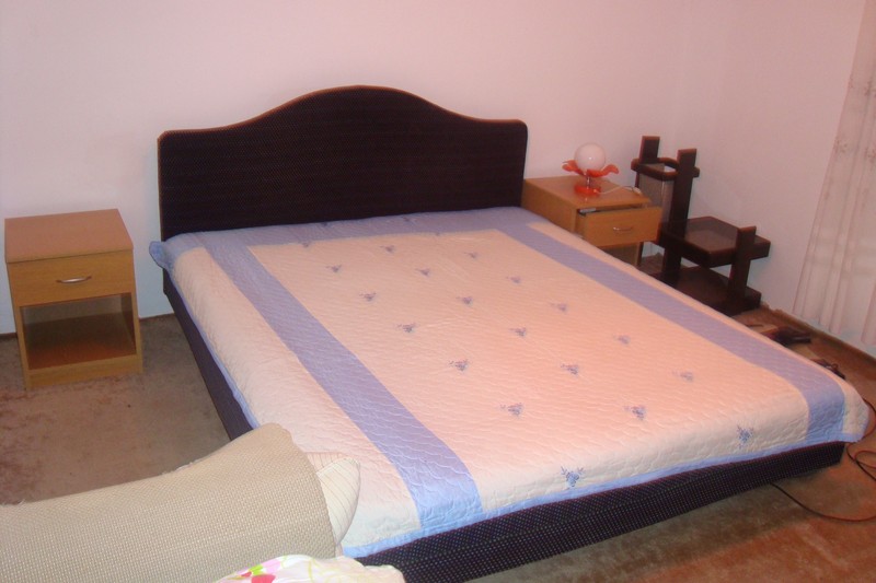 Bedroom in a house in Dobrota, Montenegro: a double bed with a dark headboard, nightstands, and a light bedspread.