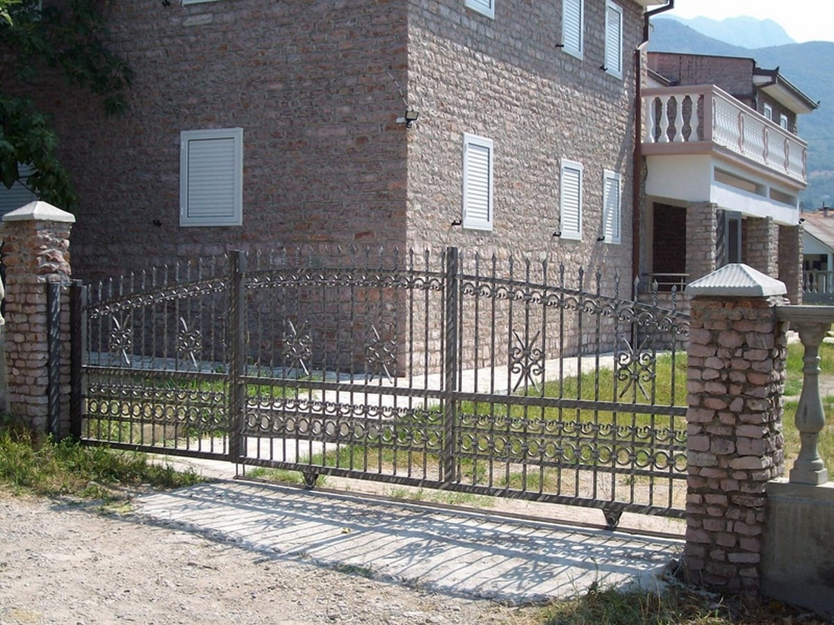 Wrought-iron gates and a natural stone facade of a villa in Bar, Montenegro, exterior view of the property.