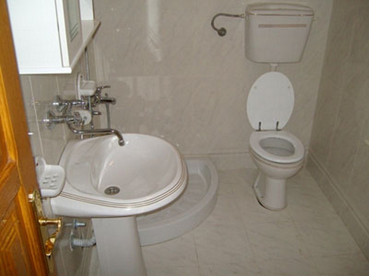 Bathroom with white fixtures and light-colored tiles in a villa in Bar, Montenegro.