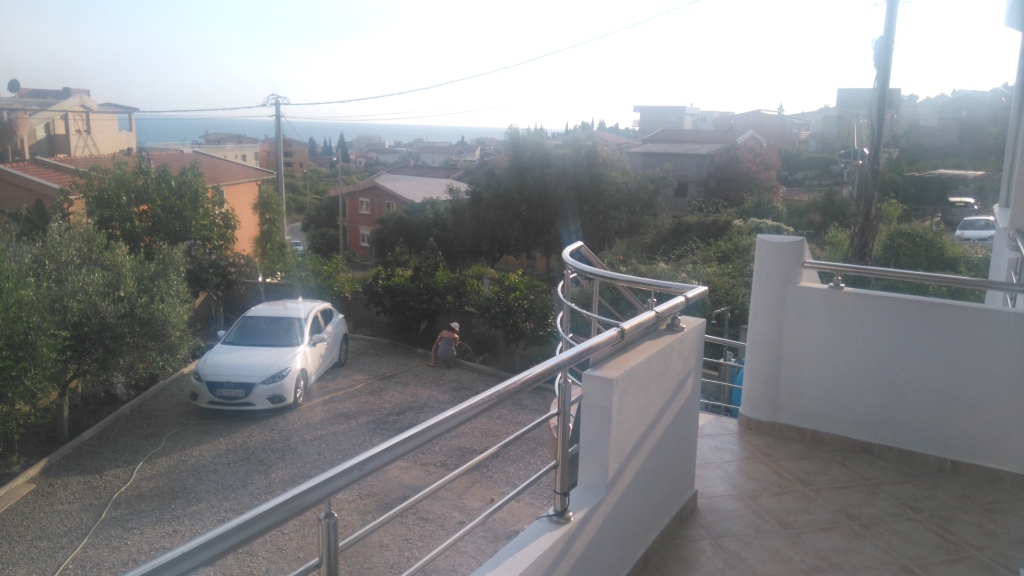 View from the balcony of a house in Shushan, Montenegro: private parking, a green garden, and panoramic sea and mountain views.
