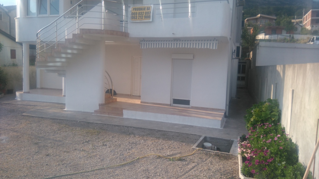 Two-story house for sale in Shushan, Montenegro: facade with an exterior staircase, terrace, and landscaped grounds.