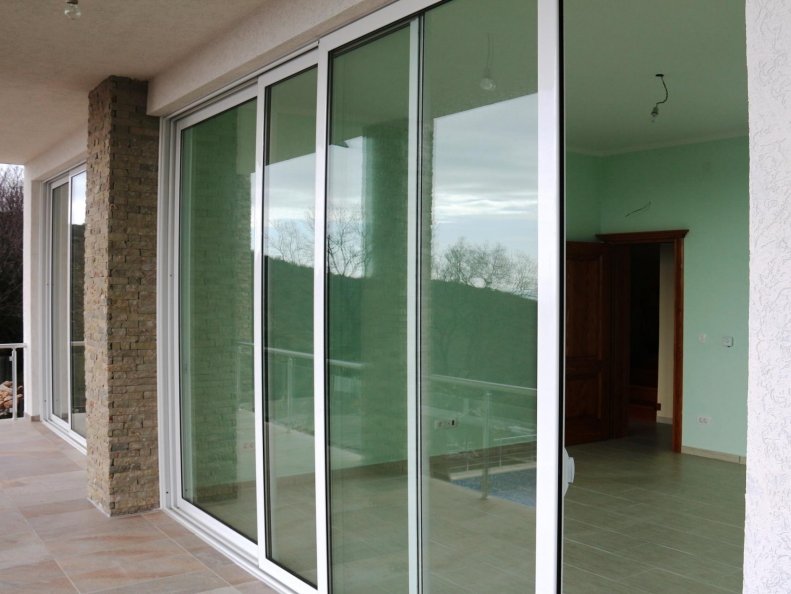 Panoramic sliding doors to the terrace of a house in Shushan, Montenegro, with mountain views and natural stone finishes.