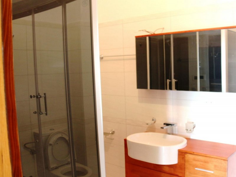 Modern bathroom with a shower cabin and vanity unit in a house in Shushan, Montenegro.