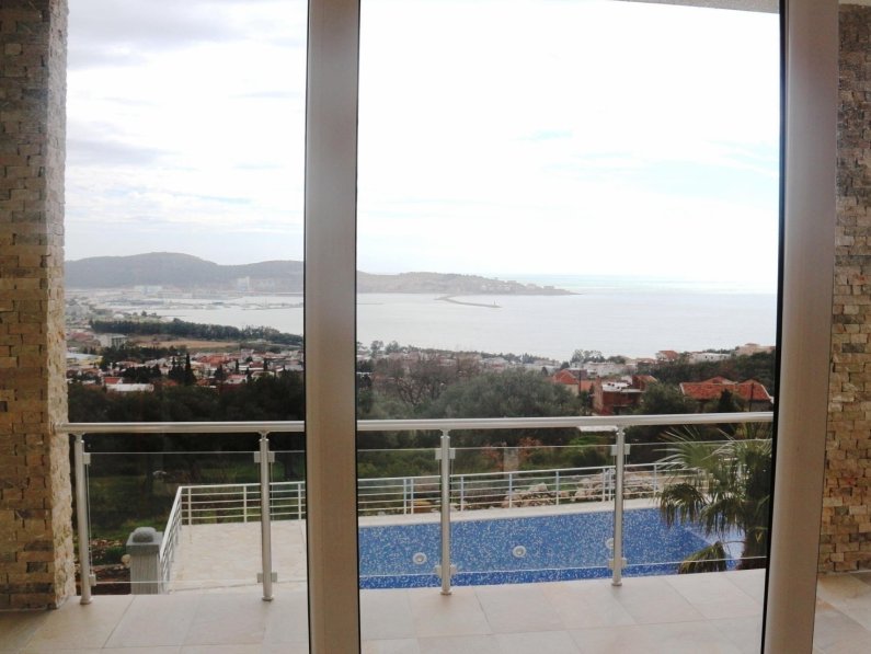 View from the living room of a house in Shushan, Montenegro: panoramic sea view, pool, and natural stone wall finishes.