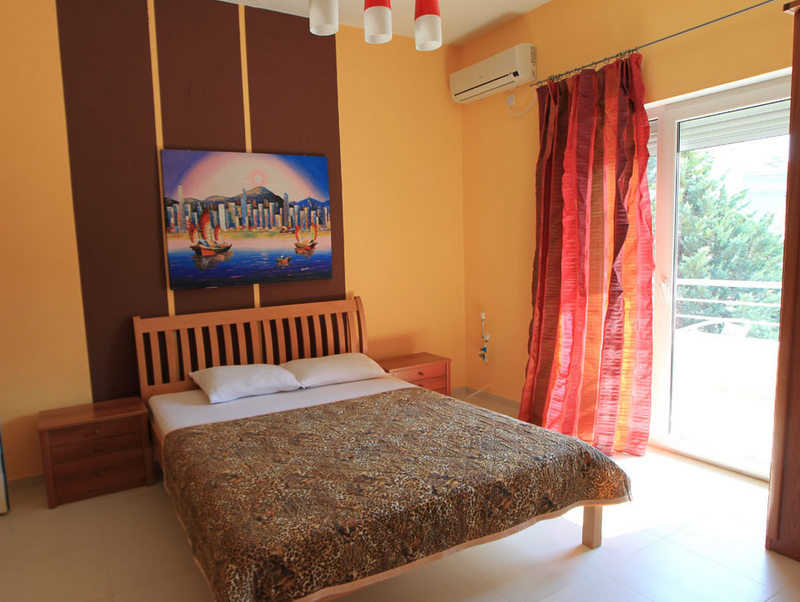 Cozy bedroom with a double bed in a hotel in Budva, Montenegro: bright interior, air conditioning, and access to the balcony.