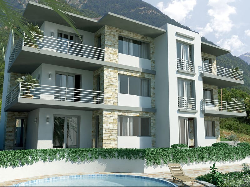 Modern villa with stone finish, balconies, and a pool in Prčanj, Montenegro: front view and mountains.