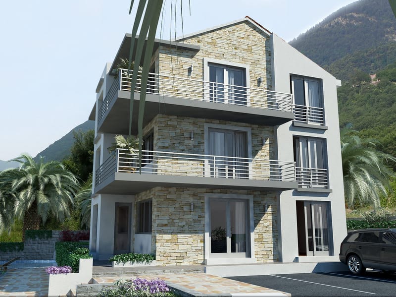 Three-story villa in Prčanj, Montenegro: modern stone finish, panoramic windows, and balconies with mountain views.
