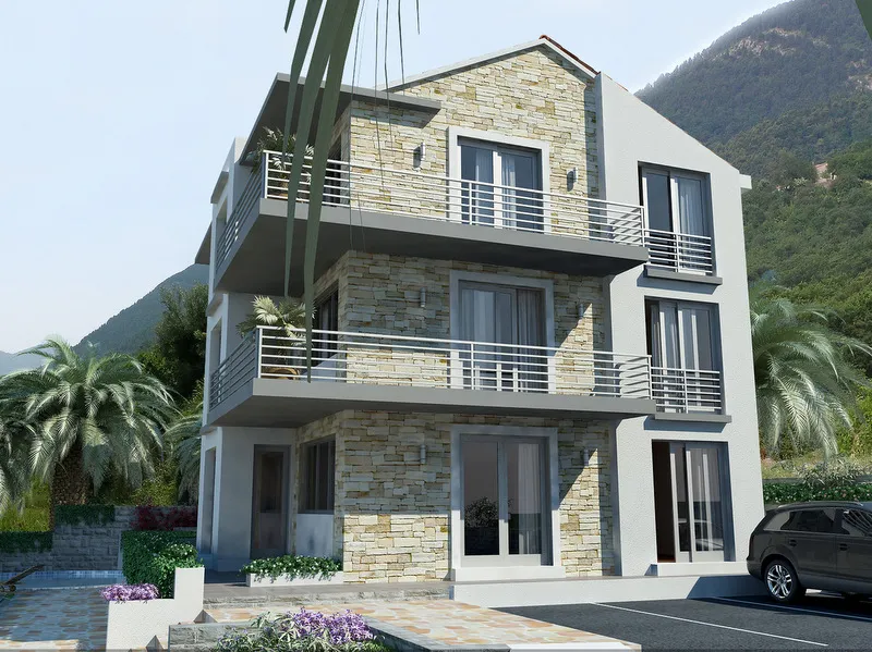 Exterior view of a modern two-story house with stone cladding, balconies, palm trees, and mountains in the background.