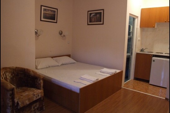 Bedroom in Hotel Bečići, Montenegro: double bed, armchair, kitchenette, and private bathroom.