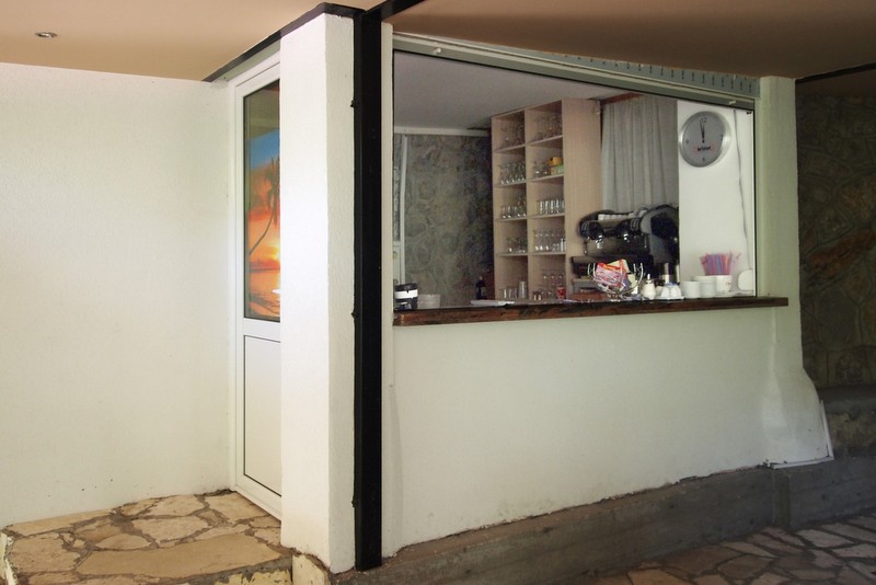 Bar counter with coffee machine and shelves in the Bečići hotel, Montenegro. Interior of the service area with stone finish.