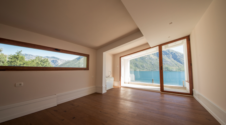 Bright living room with panoramic views of the sea and mountains in a house, Stoliv, Bay of Kotor, Montenegro. Wooden floor.
