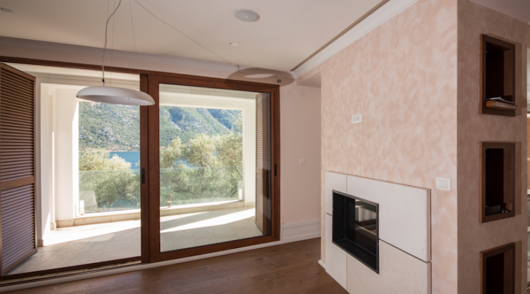 Living room with a fireplace and panoramic sea view in a house in Stoliv, Bay of Kotor, Montenegro.