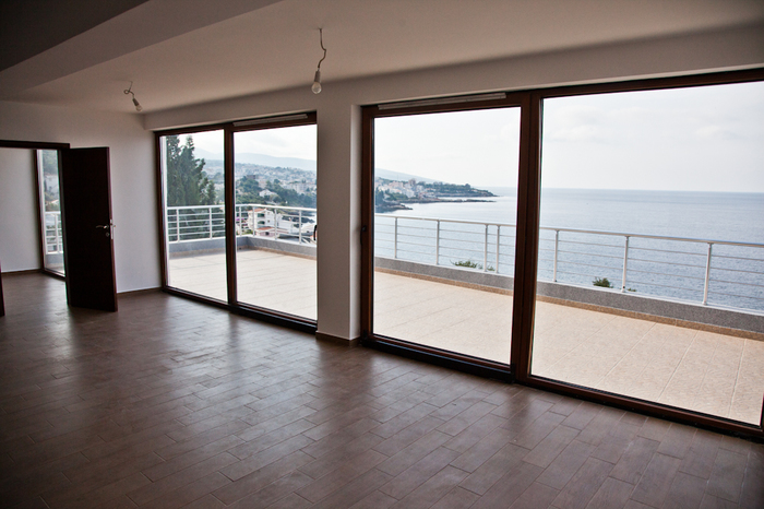 Living room with panoramic windows and a terrace overlooking the sea in an apartment, Dobri Vody, Montenegro.