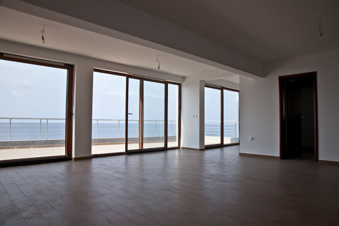 Spacious living room in an apartment in Dobri Vody, Montenegro, with panoramic windows and direct sea view.