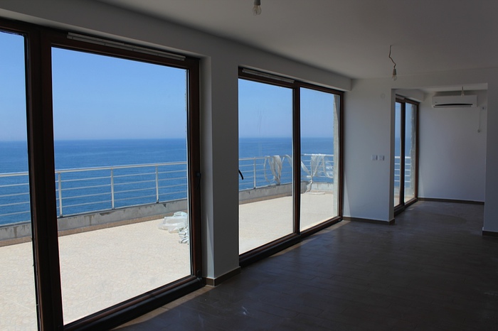 Living room with panoramic windows and a terrace overlooking the sea in an apartment, Dobri Vody, Montenegro.