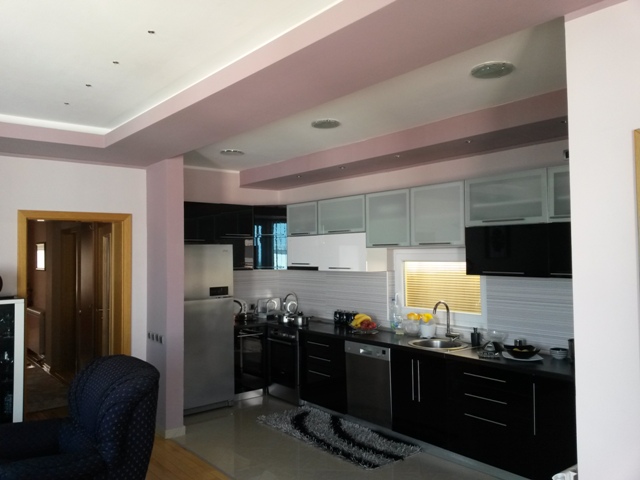 Modern kitchen with black-and-white cabinets and built-in appliances in a house for sale, Ulcinj, Montenegro.