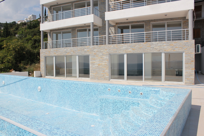 Modern residential complex with a pool and stone cladding in Dobri Vody, Montenegro: view of the terraces and apartments.