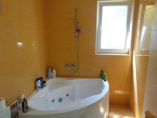 Bathroom with a corner whirlpool tub and orange tiles in a house for sale, Ulcinj, Montenegro.