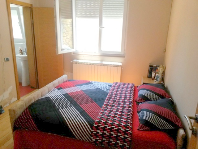 Cozy bedroom with a double bed in a house for sale in Ulcinj, Montenegro, with access to a separate bathroom.