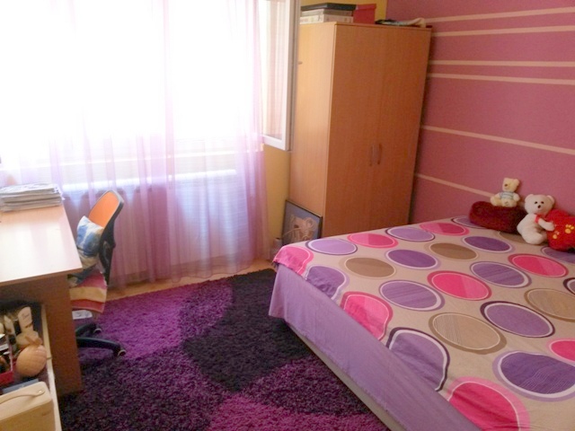 Cozy bedroom in a house in Ulcinj, Montenegro: double bed, desk, wardrobe, and a purple rug.