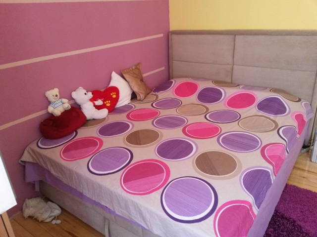 Bedroom with a double bed in a house in Ulcinj, Montenegro: bright interior, upholstered headboard, and wooden floor.